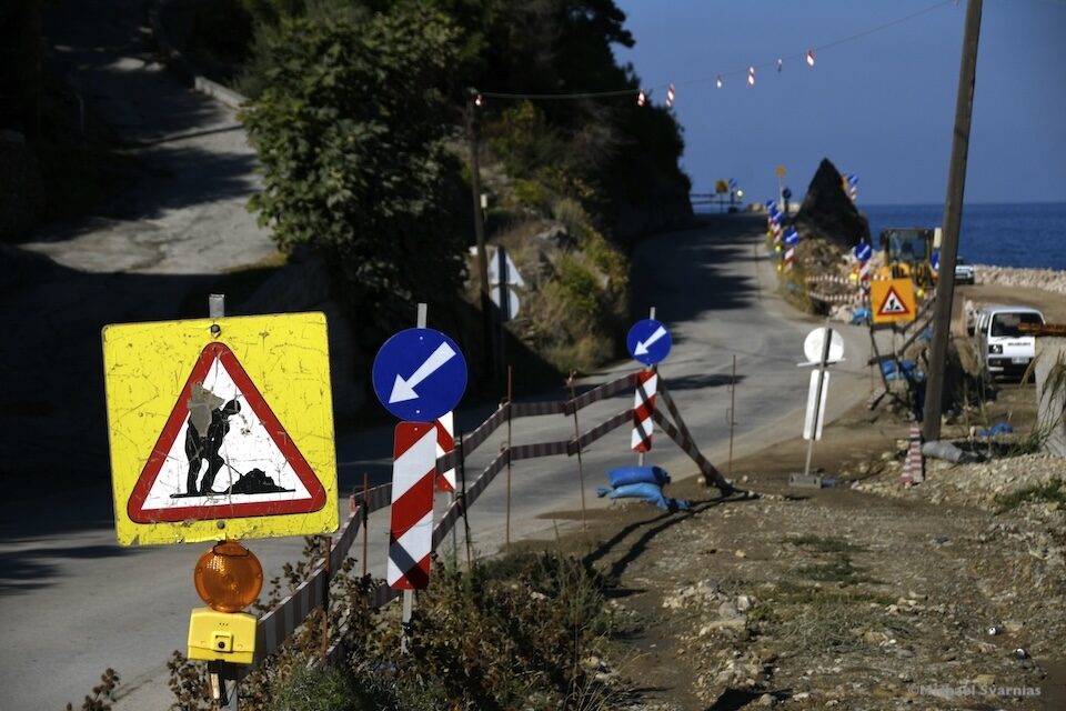 Προειδοποιητικές πινακίδες, βέλη κατεύθυνσης και προστατευτική περίφραξη δίπλα στον παραθαλάσσιο δρόμο.