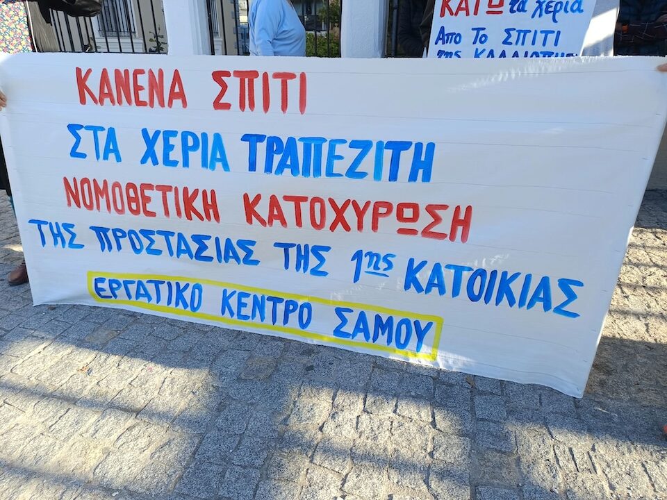 Πανό του Εργατικού Κέντρου Σάμου με αίτημα τη νομοθετική κατοχύρωση της προστασίας της πρώτης κατοικίας.